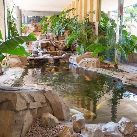 Indoor koi pond and tropical greenery inside the former Burgers Park Hotel lobby